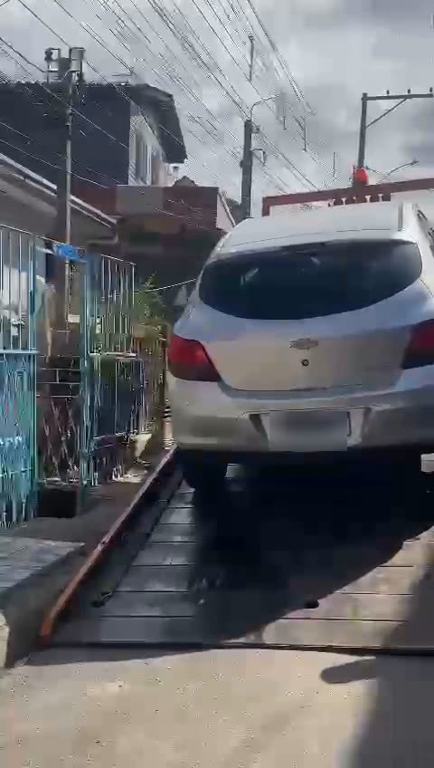 Carro sendo levado pelo guincho em frente a uma residência